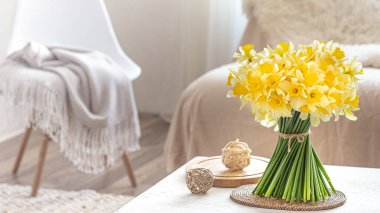 Oturma odasının iç tarafında bahar çiçekleri olan kompozisyon. Dekor ve konfor kavramı.