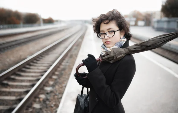 Chica sosteniendo paraguas en la estación — Foto de Stock