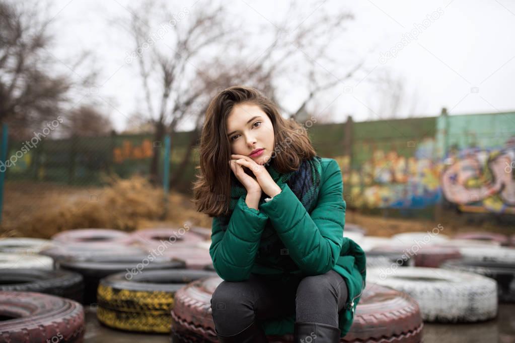 Teen girl sitting on tyres