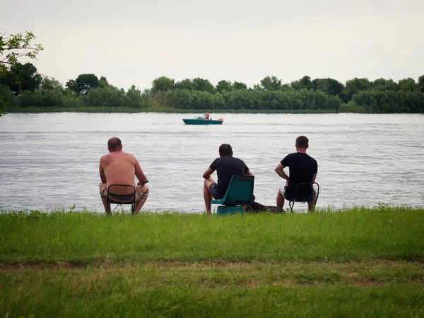 Homens que pescam na margem do rio — Fotografia de Stock