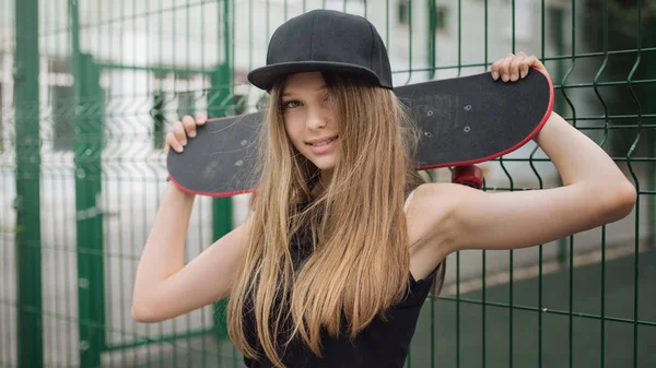 Mulher jovem com skate — Fotografia de Stock