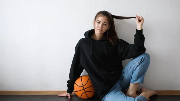 Katta oturan genç güzel kız basketbol oyuncusu 