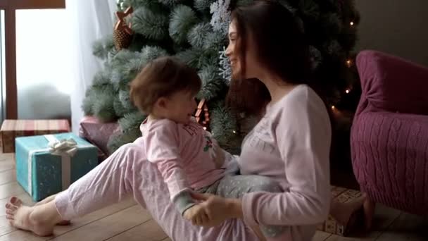 Boldog fiatal anya a lányával, a karácsonyfa — Stock videók