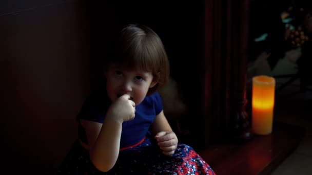 Счастливая маленькая девочка ест конфеты — стоковое видео