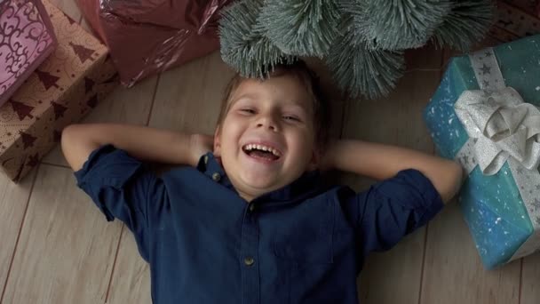 Kisgyermekek élvezik a karácsonyfa, ajándékok — Stock videók