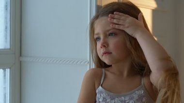 Kış günü. Düşen kar pencereden dışarı arayan kız