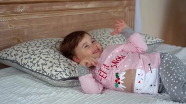 Mutlu küçük kız yatakta yatarken pijama