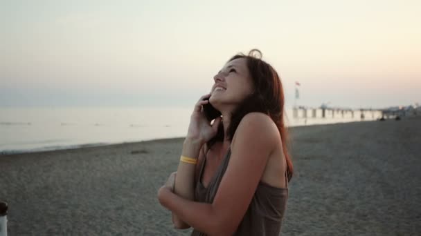 Genç kız plajda telefonda konuşuyor — Stok video