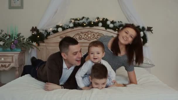 幸福的年轻家庭躺在床上. — 图库视频影像
