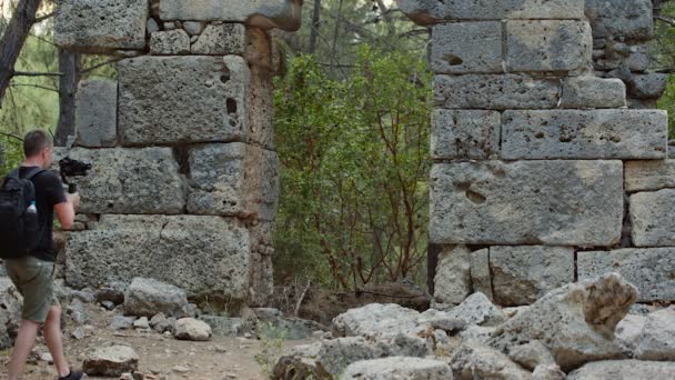 Un viajero filma imágenes de vídeo en las ruinas de la ciudad antigua — Vídeo de stock