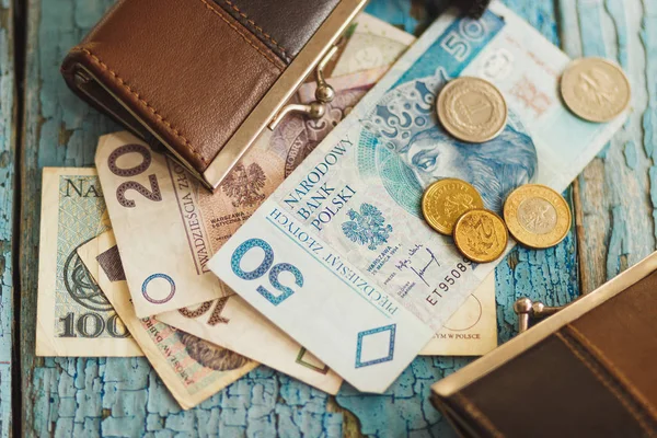 Polish zloty with a wallet on the wooden background