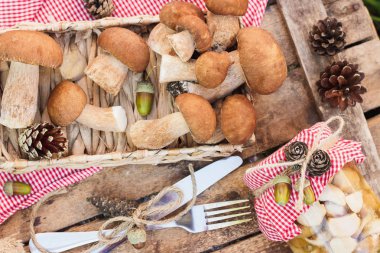 Çiğ beyaz mantar, çam kozalakları ahşap masa üzerinde kuru süslemeleri ile