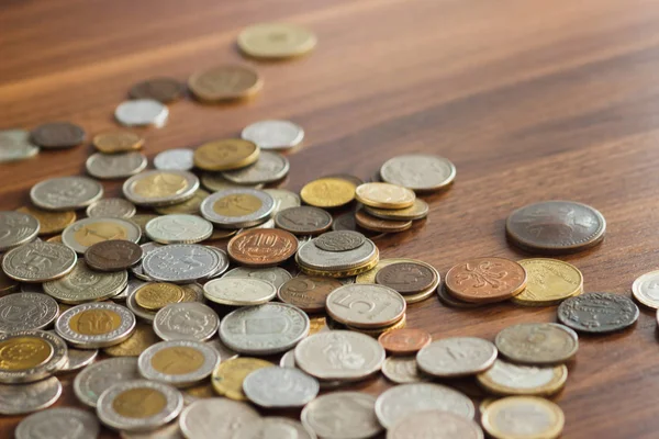 Diferentes monedas de oro y plata en la mesa de madera — Foto de Stock