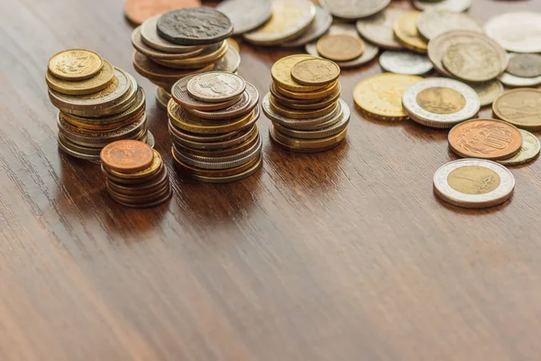 Різні золоті та срібні монети на дерев'яному столі — стокове фото