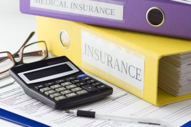 Temiz sigorta formu, klasörler, gözlük, hesap makinesi ve kalem