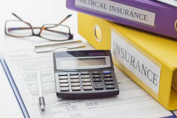 Schoon verzekeringsformulier, mappen, pen, bril en calculator — Stockfoto