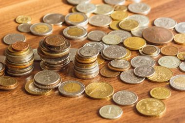 Farklı altın ve gümüş collector's sikkeleri üzerinde ahşap masa
