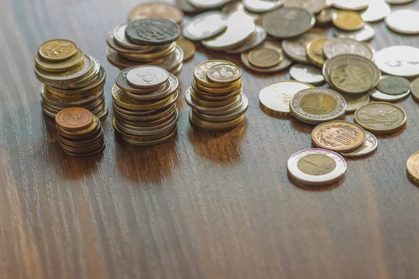Farklı altın ve gümüş collector's sikkeleri üzerinde ahşap masa