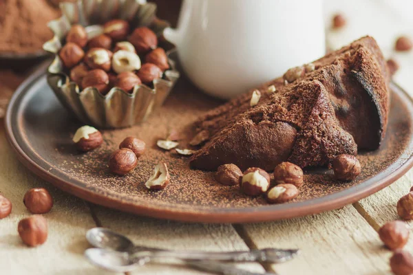 Kawałek ciasto czekoladowe, orzechy laskowe i słoik z mleka — Zdjęcie stockowe