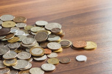 Farklı altın ve gümüş collector's sikkeleri üzerinde ahşap masa