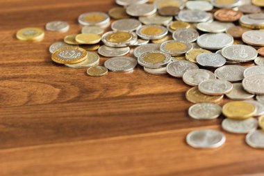 Farklı altın ve gümüş collector's sikkeleri üzerinde ahşap masa