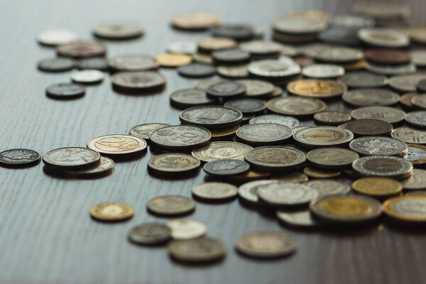 Different gold and silver collector's coins on the wooden table