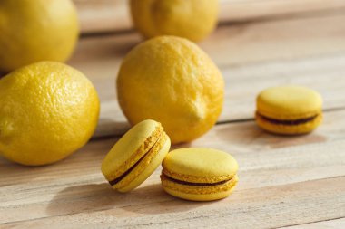 Sarı Fransız macarons ahşap kurullarında limon ile