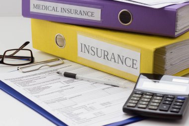 Temiz sigorta formu, klasör, kalem, gözlük ve hesap makinesi