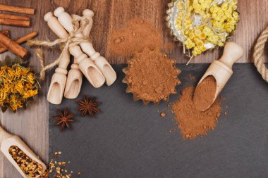 Tasarlayacağım kayrak slone arka plan üzerinde ahşap Kepçe içinde farklı baharatlar