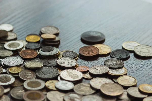 Diferentes monedas de oro y plata en la mesa de madera — Foto de Stock