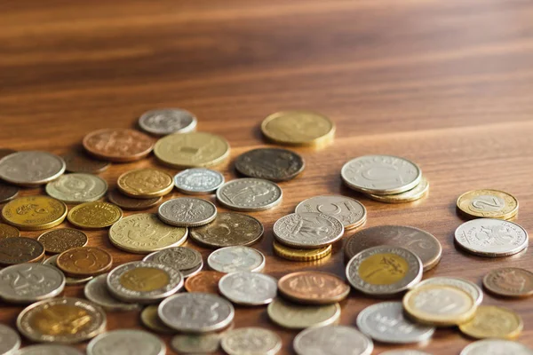 Різні золоті та срібні колекційні монети на дерев'яному столі — стокове фото
