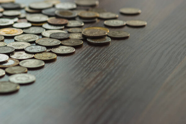 Different gold and silver collector's coins on the wooden table