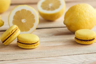 Sarı Fransız macarons ahşap kurullarında limon ile