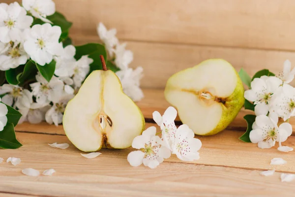 Το ώριμο αχλάδι και το άνθος πάνω στο ξύλινο τραπέζι — Φωτογραφία Αρχείου