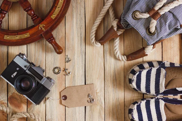 Gestreifte Hausschuhe, Kamera, Tasche und maritime Dekorationen auf dem Holzgrund — Stockfoto