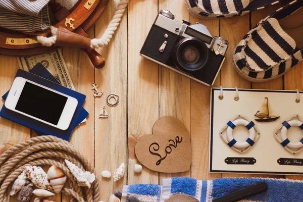 Striped slippers, camera, phone and maritime decorations, background