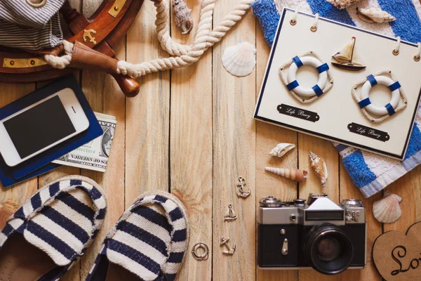 Striped slippers, camera, phone and maritime decorations, top view