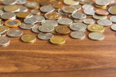 Farklı altın ve gümüş collector's sikkeleri üzerinde ahşap masa