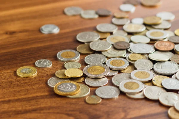 Різні золоті та срібні колекційні монети на дерев'яному столі — стокове фото