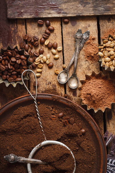 Roasted black and green coffee beans and ground coffee in the plate