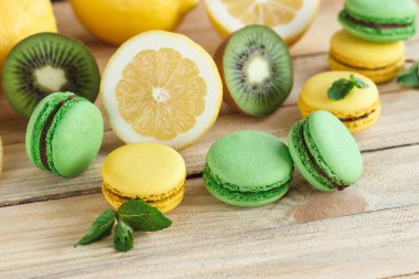 Yeşil ve sarı macarons kivi, limon ve nane süslemeleri ile