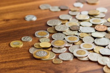 Farklı altın ve gümüş collector's sikkeleri üzerinde ahşap masa