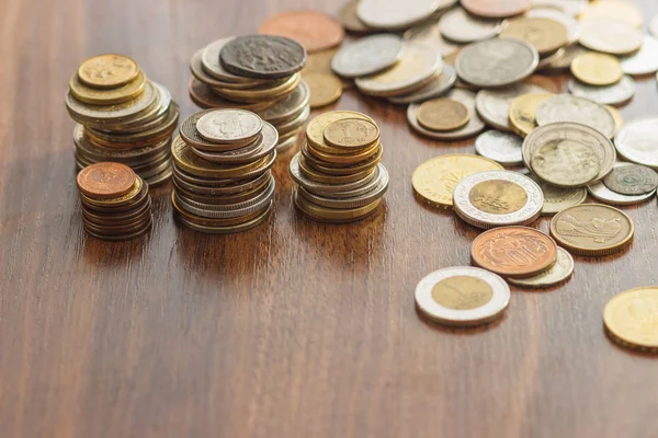 Diferentes monedas de oro y plata en la mesa de madera — Foto de Stock