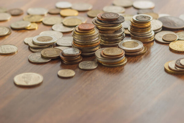 Different gold and silver collector's coins on the wooden table