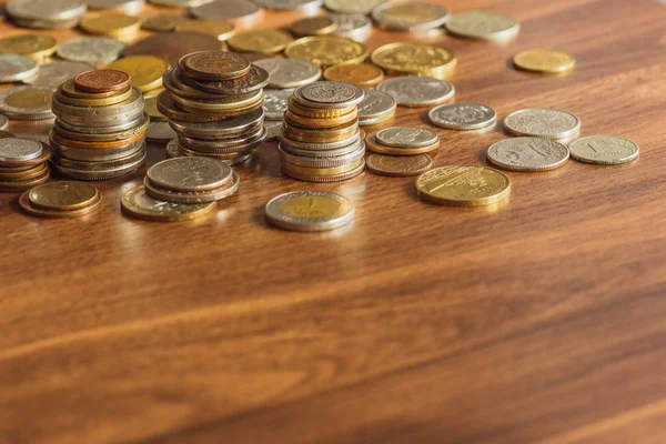 Diferentes monedas de oro y plata en la mesa de madera — Foto de Stock