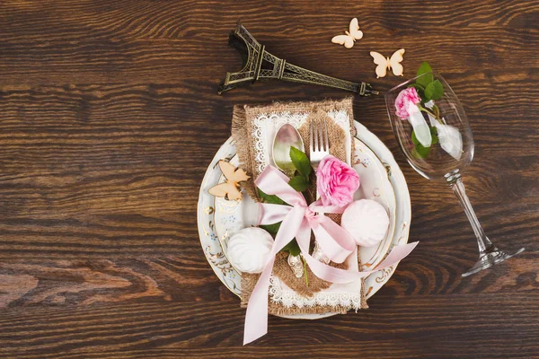Servies en bestek met gezwollen licht roze rozen — Stockfoto