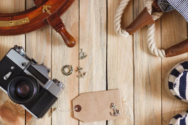 Gestreifte Hausschuhe, Kamera, Tasche und maritime Dekorationen auf dem Holzgrund — Stockfoto