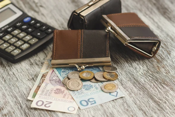 Polierter Zloty mit kleinen Portemonnaies und Taschenrechner auf dem hölzernen Hintergrund — Stockfoto