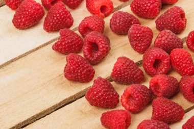 Hafif ahşap arka plan üzerinde kırmızı ahududu