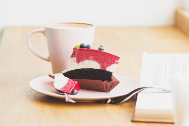 Fincan kapuçino ve tatlı plaka üzerinde bir parça